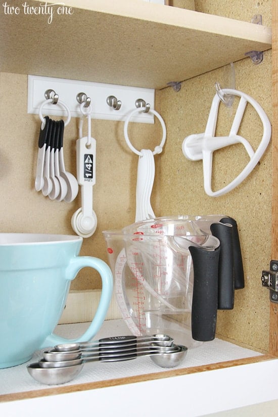 Organize kitchen cabinet with hooks for measuring spoons and other baking utensils. (Image and Tip Credit: Two Twenty One)